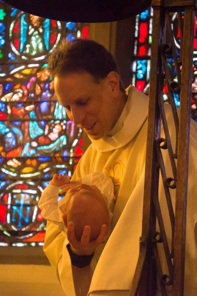 Adam Trambley baptizing infant at St. John's Episcopal Church